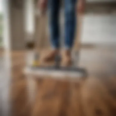 Homeowner Maintenance Tips for Laminate Floors Homeowner using a mop on laminate wood flooring with care