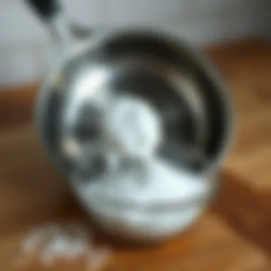 Baking soda in a bowl with a stainless steel pan