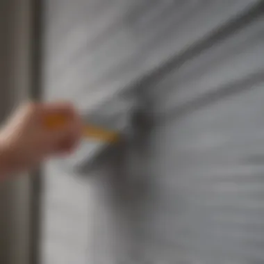 A person using a microfiber cloth to clean a metal blind